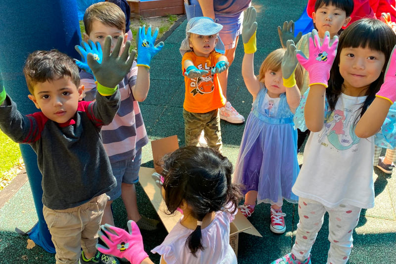 Kids holding up gloved hands